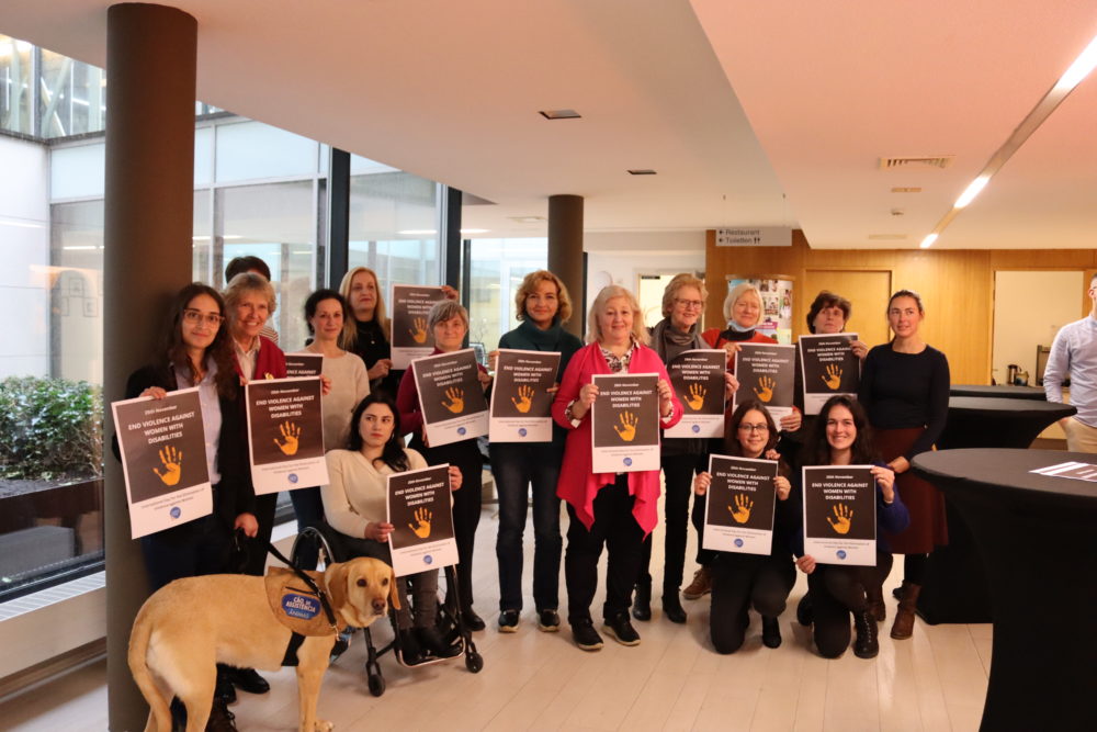 The women's committee during the meeting on 23 November. Each of them holds up a sign that reads: end violence against women with disabilities