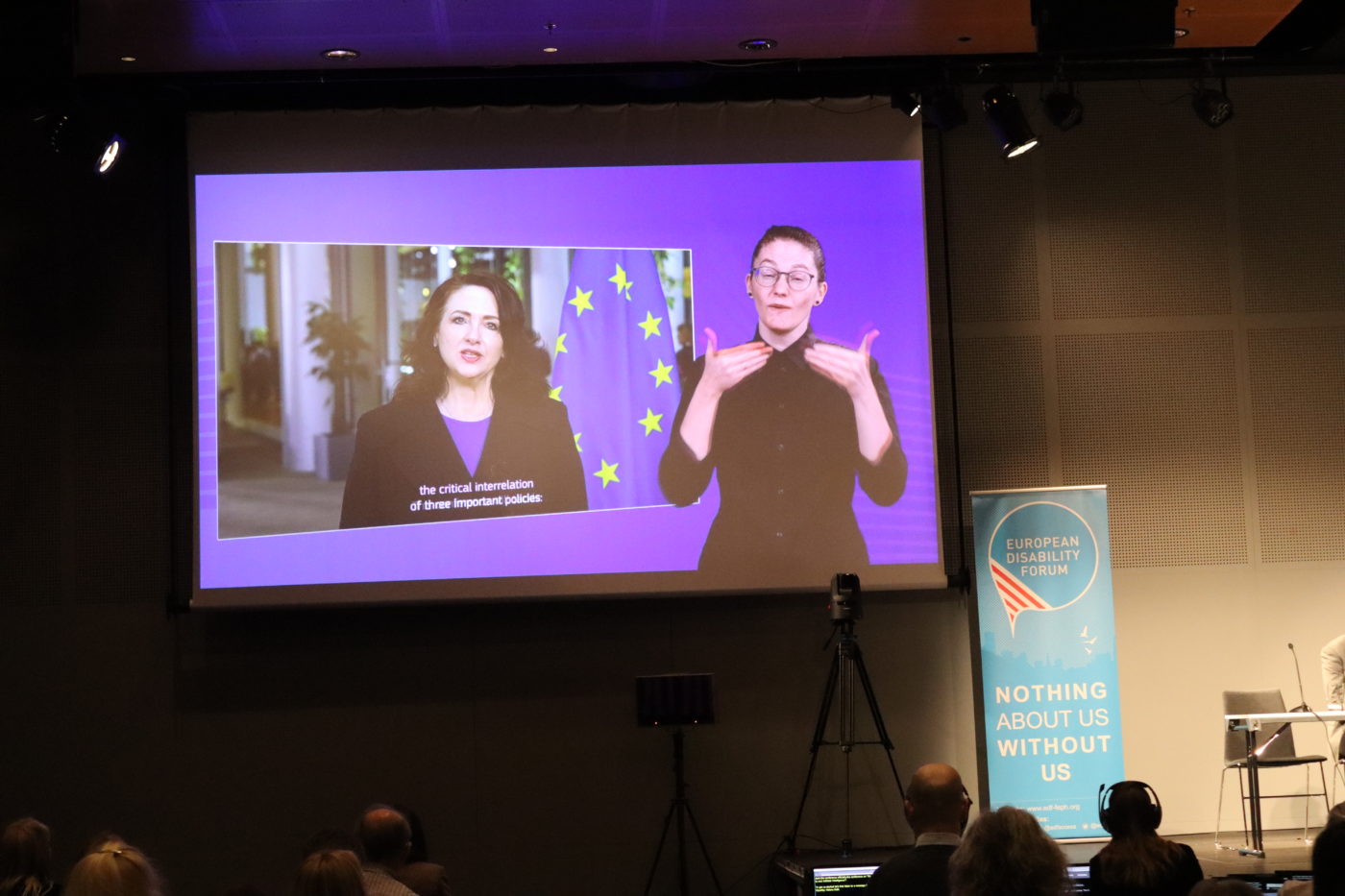 EU Commissioner for Equality Helena Dalli speaks on a screen with sign interpreter and captions