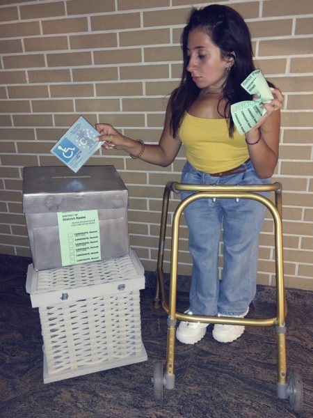 Woman with disabilities pretends to vote on a makeshift ballot box by castingher EU parking Card inside