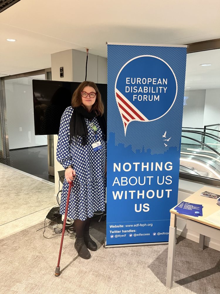 Adela Odrihocka with a banner of the European Disability Forum