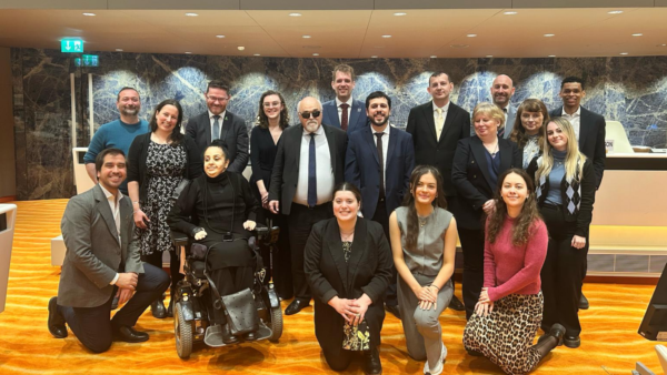 Group of representatives of organisations of persons with disabilities poses together and smiles