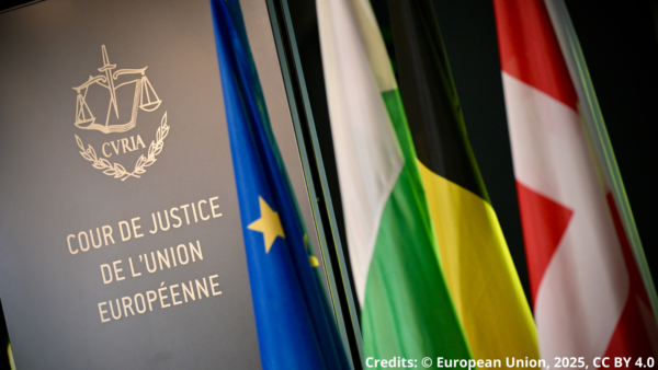 A black wall with the a golden logo of the European Court of Justice. Next to it, the flag of the EU and 3 flags of EU countries