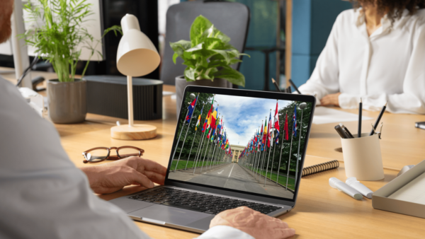 A man looks at a photo of the UN in Geneva in his laptop