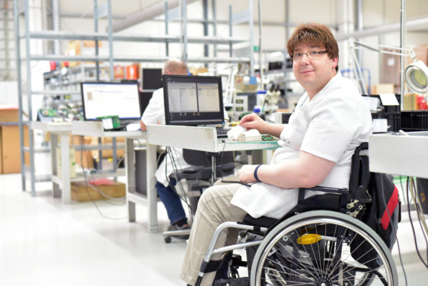 A man in a wheelchair works in a laboratory